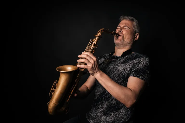 fotografía profesional de saxofonista tocando un solo con un fondo negro