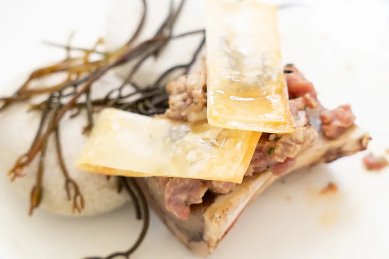 Plato alta cocina de hueso de tuétano con crujiente de queso