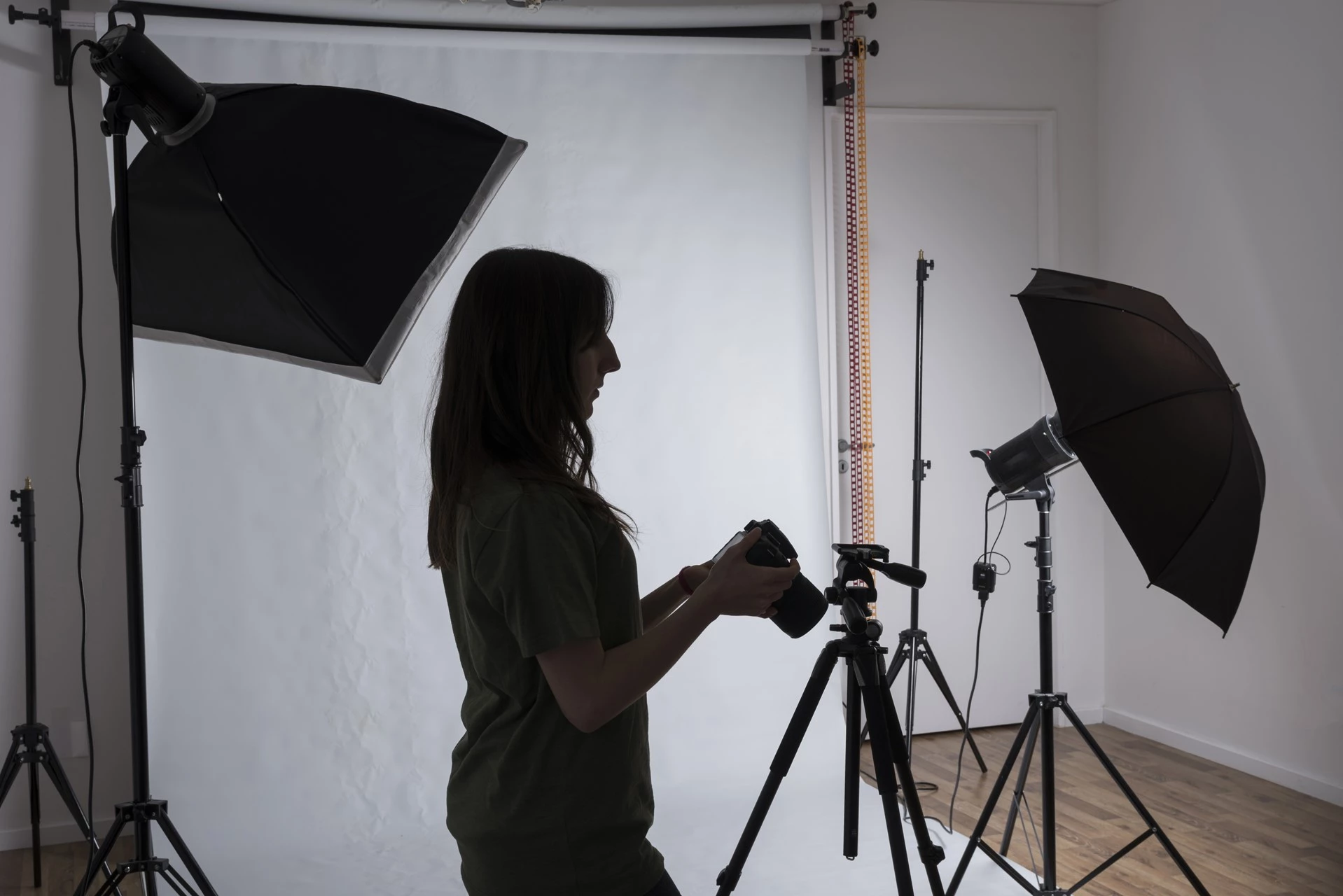 Mujer en estudio de fotografía profesional ajustando la cámara